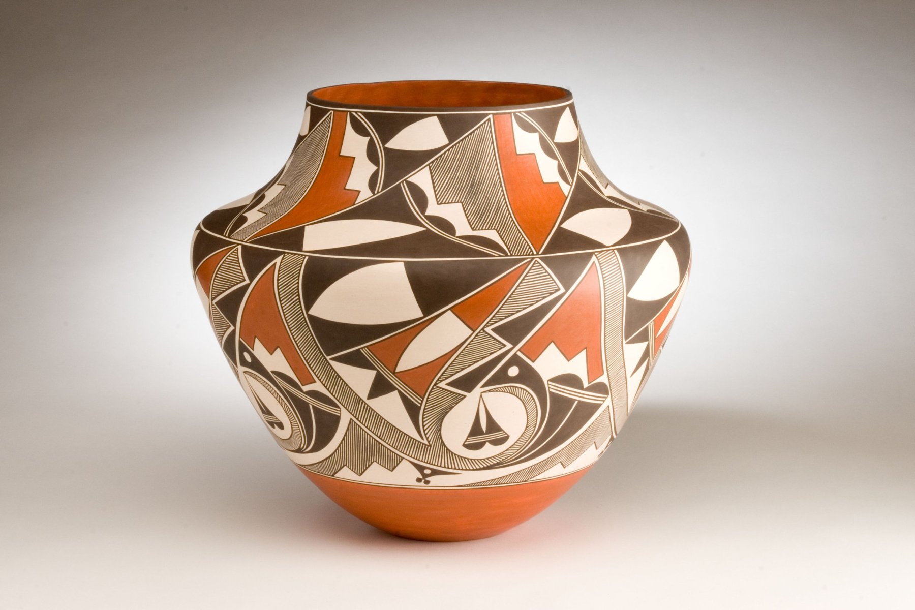 Large pottery jar painted with bold black, cream, and red-orange designs and fine-line hatching above a red-orange base