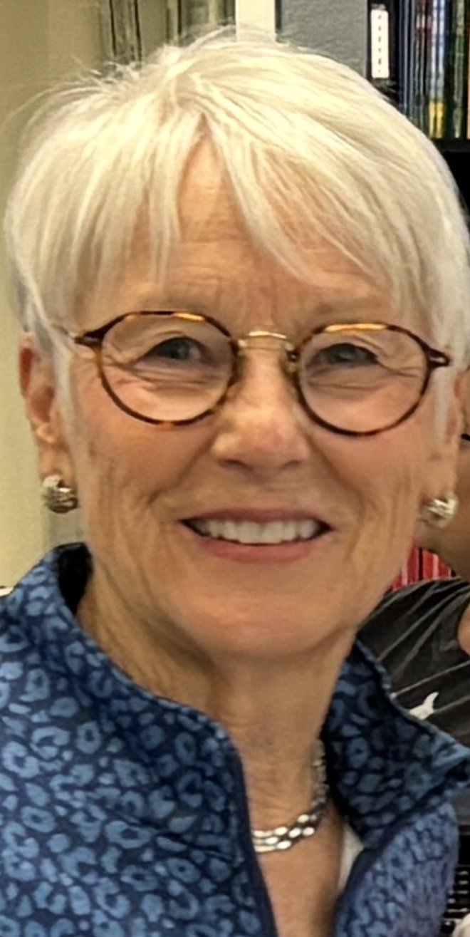 Portrait of Judith Kennedy Lavender, smiling, with short white hair and round glasses