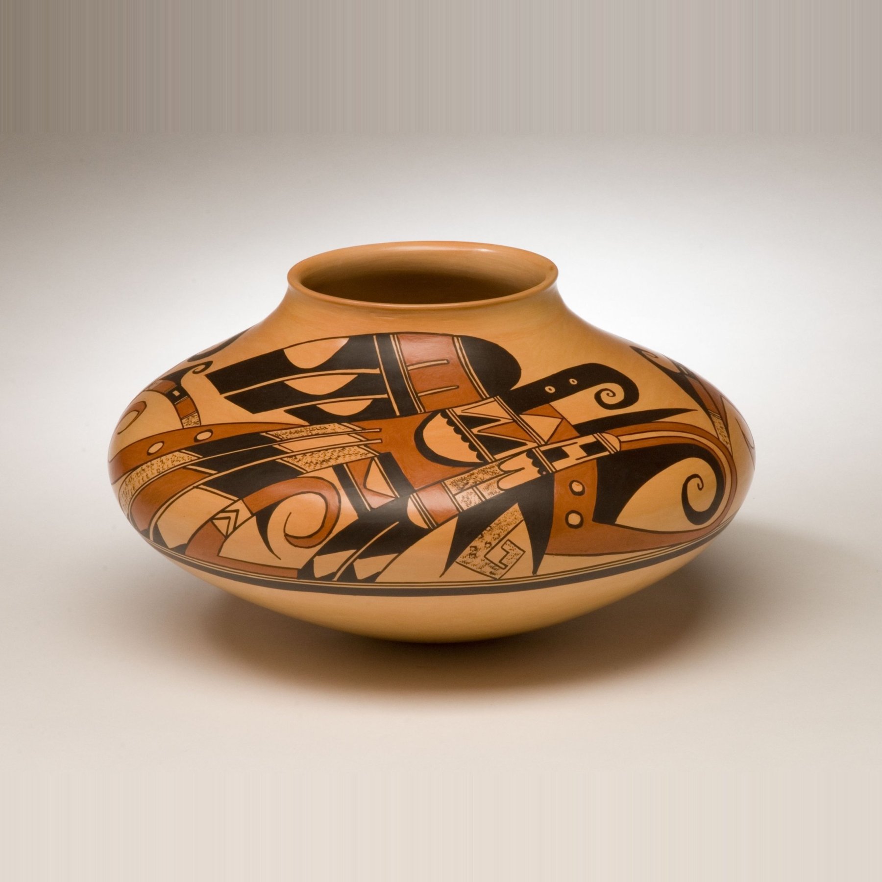 Hopi pottery jar by Jean Sahme with bold black and red-brown designs on a golden clay body